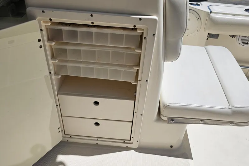 Slide: The Image of 2004 Pursuit 3070 Express boat storage compartment with drawers and shelves. - 24