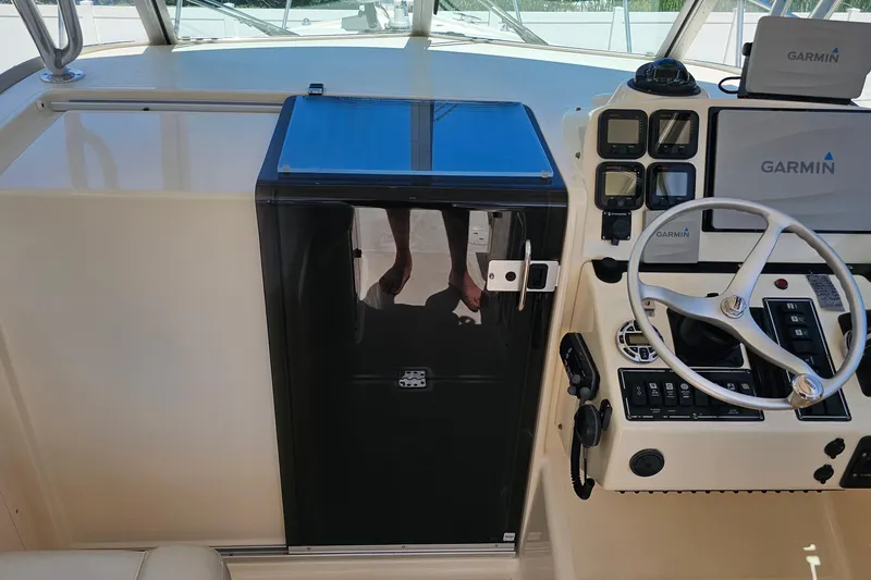 Slide: The Image of 2004 Pursuit 3070 Express boat helm with Garmin navigation system and steering wheel. - 26