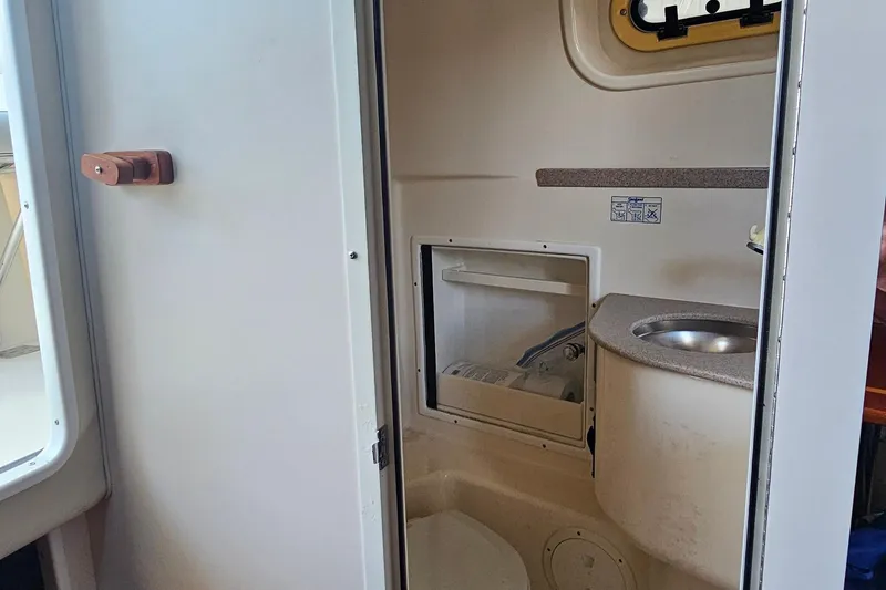 Slide: The Image of 2004 Pursuit 3070 Express boat interior with compact bathroom and sink. - 32