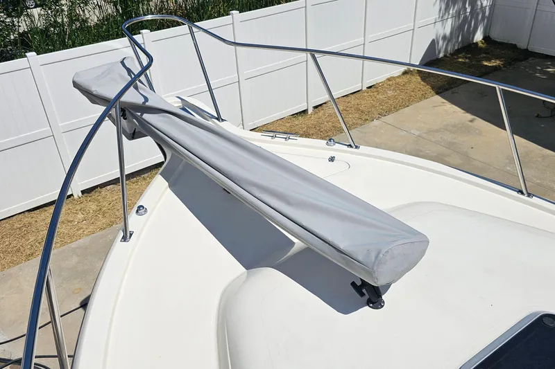 Slide: The Image of 2004 Pursuit 3070 Express boat deck with covered anchor, white fencing background. - 7