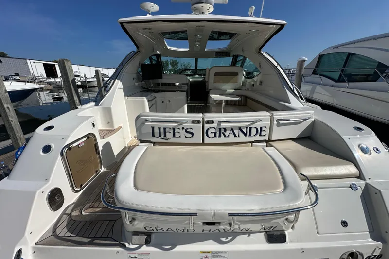 Slide: The Image of 2012 Sea Ray 470 Sundancer yacht docked, featuring spacious seating and sleek design. - 5