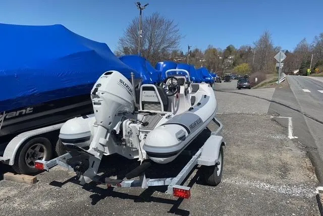 Slide: The Image of 2023 Highfield Sport 330 inflatable boat on trailer, parked outdoors. - 8