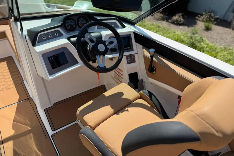 Slide: The Image of 2021 MasterCraft NXT24 boat interior with tan seating and modern dashboard controls. - 19
