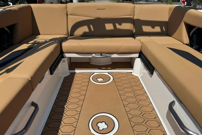 Slide: The Image of 2021 MasterCraft NXT24 boat interior with tan seating and hexagonal patterned flooring. - 21