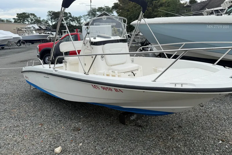Slide: The Image of 2007 Boston Whaler 200 Dauntless boat on gravel lot, featuring sleek design and white hull. - 2