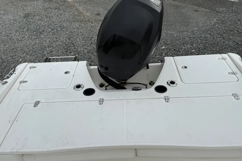 Slide: The Image of 2007 Boston Whaler 200 Dauntless boat stern with outboard motor on gravel surface. - 5