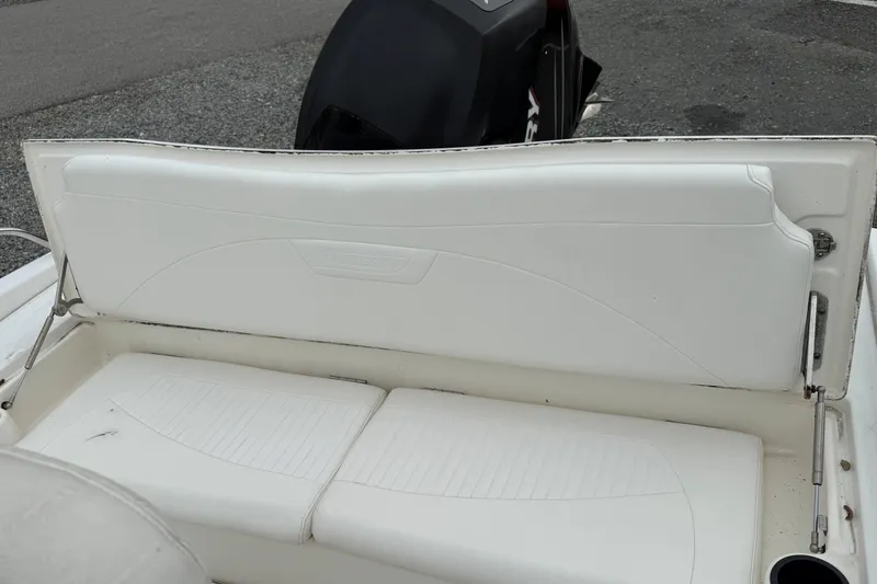 Slide: The Image of 2007 Boston Whaler 200 Dauntless boat seat with white upholstery and visible engine. - 6