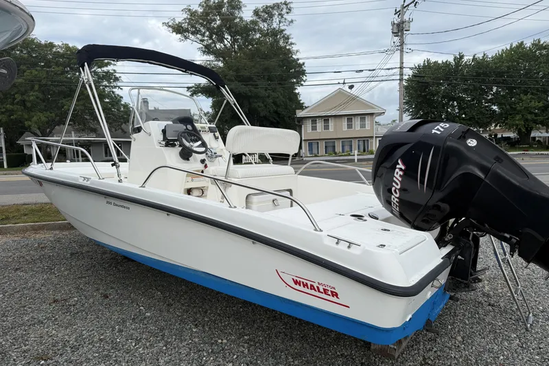 Slide: The Image of 2007 Boston Whaler 200 Dauntless boat with Mercury 175 engine, parked on gravel. - 7