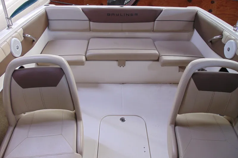 Slide: The Image of 2015 Bayliner 180 Bowrider interior with beige seating and spacious layout. - 10