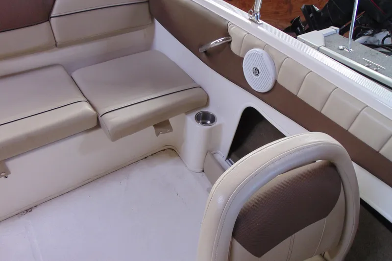 Slide: The Image of Interior of 2015 Bayliner 180 Bowrider boat with beige seating and cup holder. - 11