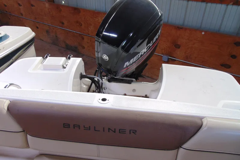 Slide: The Image of 2015 Bayliner 180 Bowrider with Mercury outboard motor in a wooden dock setting. - 5