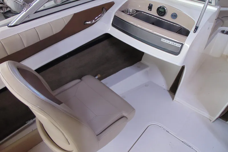 Slide: The Image of Interior of 2015 Bayliner 180 Bowrider boat with beige seating and dashboard. - 7