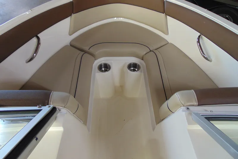 Slide: The Image of 2015 Bayliner 180 Bowrider interior with tan seating and cup holders. - 9