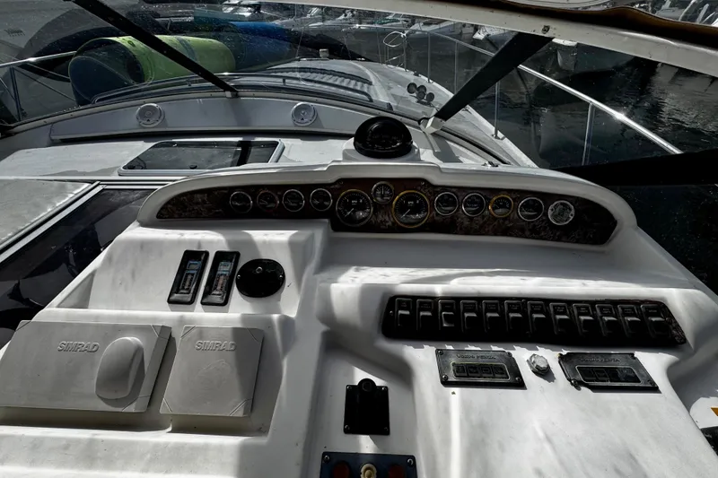 Slide: The Image of Control panel of a 2000 Trojan 440 Express boat with gauges and switches. - 12