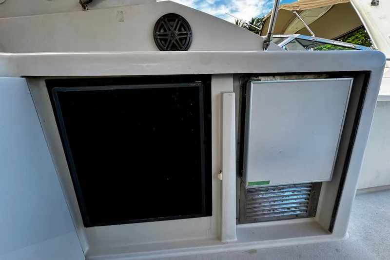 Slide: The Image of Trojan 440 Express 2000 boat interior with built-in refrigerator and storage compartment. - 13