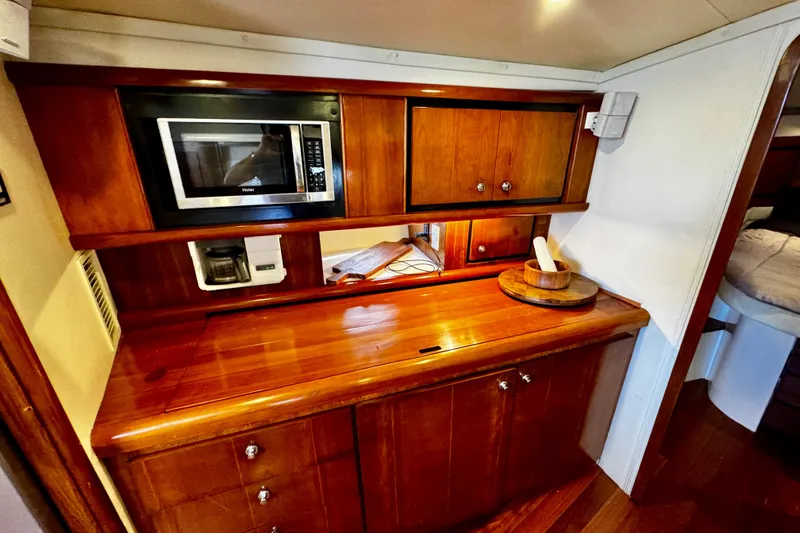Slide: The Image of Luxurious wooden interior of 2000 Trojan 440 Express yacht with microwave and coffee maker. - 21