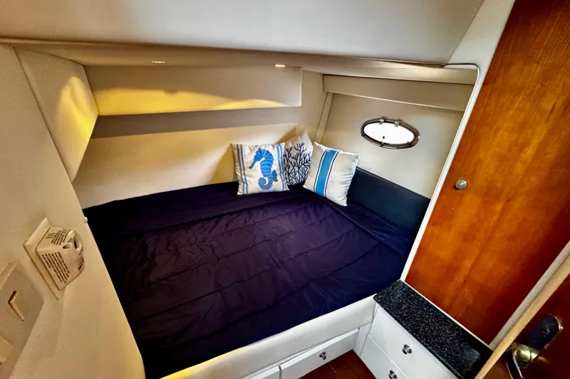 Slide: The Image of Cozy cabin interior of 2000 Trojan 440 Express yacht with nautical-themed pillows. - 25