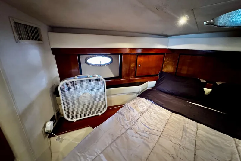Slide: The Image of Cozy cabin interior of 2000 Trojan 440 Express yacht with bed and fan. - 26