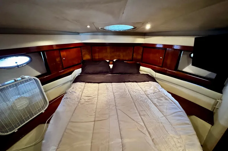Slide: The Image of Luxurious cabin interior of 2000 Trojan 440 Express yacht with cozy bed and elegant wood paneling. - 27