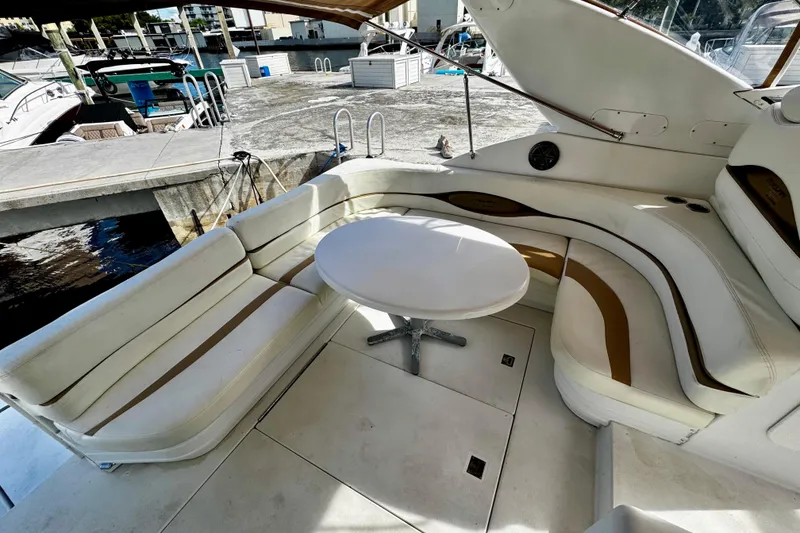 Slide: The Image of Luxury seating area on a 2000 Trojan 440 Express yacht, featuring white and tan upholstery. - 5