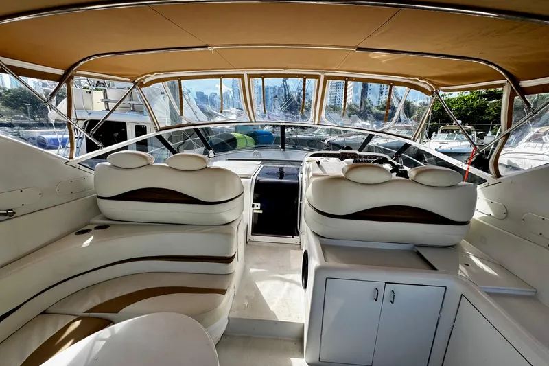 Slide: The Image of Interior of a 2000 Trojan 440 Express yacht with luxurious seating and helm. - 7