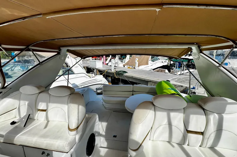 Slide: The Image of Interior view of a 2000 Trojan 440 Express yacht with white seating and canopy. - 8