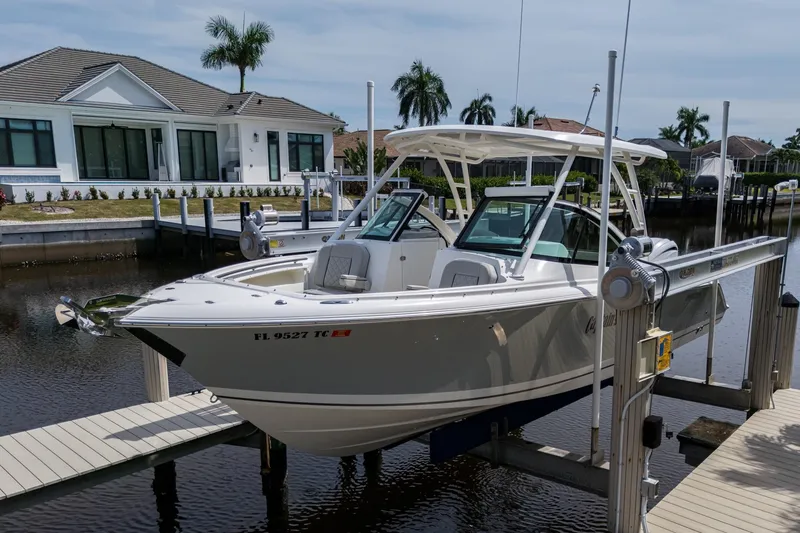 The Image of 2022 Pursuit DC 246 Dual Console boat docked near waterfront home. - 0