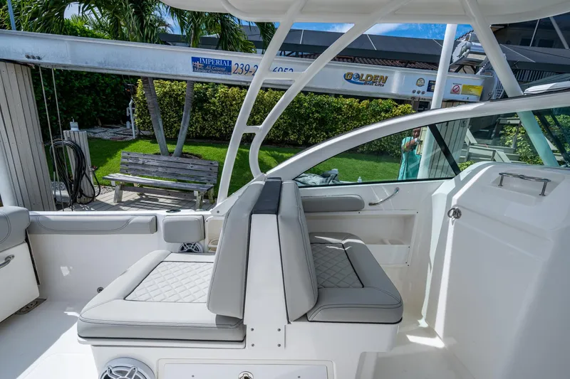 Slide: The Image of 2022 Pursuit DC 246 Dual Console boat interior with cushioned seating and sleek design. - 20