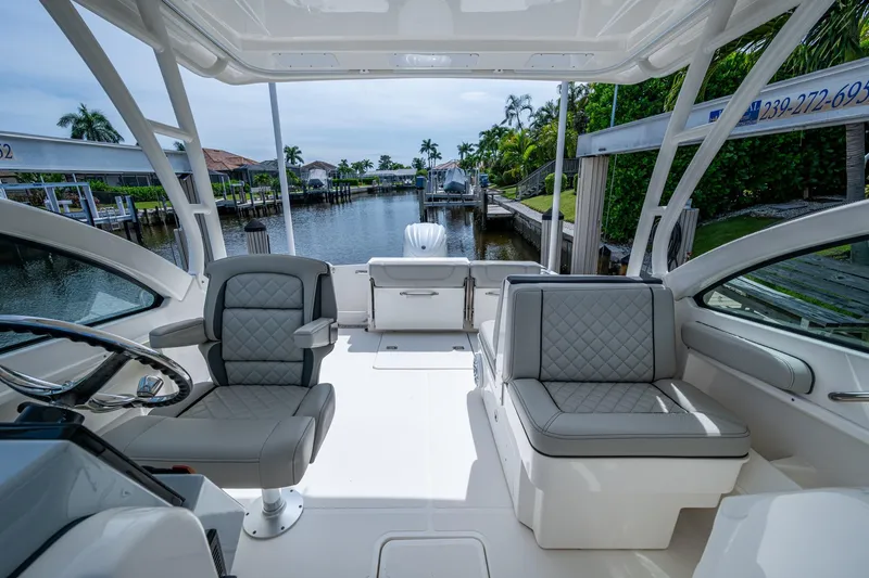 Slide: The Image of 2022 Pursuit DC 246 Dual Console boat interior with luxurious seating and waterfront view. - 21