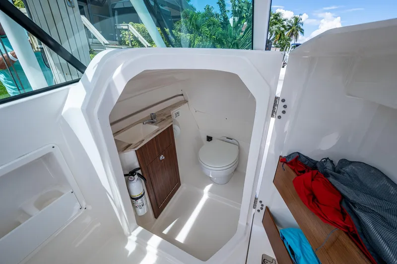 Slide: The Image of 2022 Pursuit DC 246 Dual Console boat interior with compact bathroom and storage. - 25