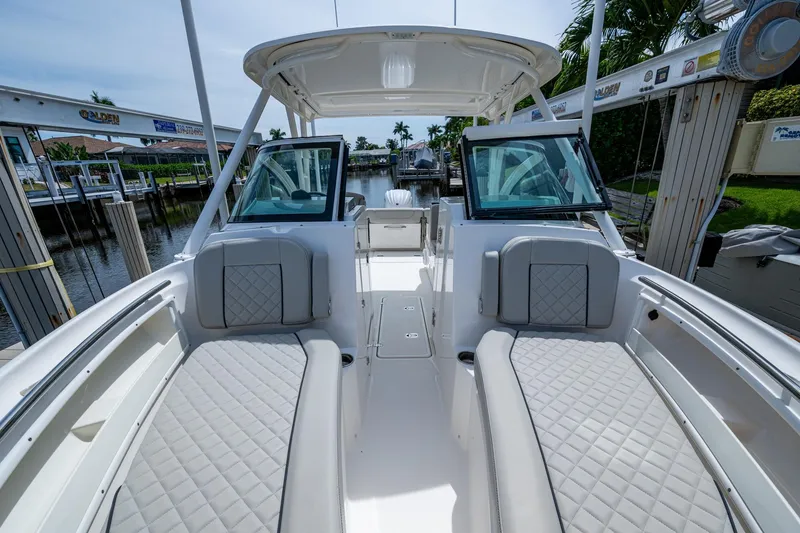 Slide: The Image of 2022 Pursuit DC 246 Dual Console boat interior with cushioned seating and open deck. - 27