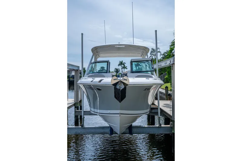 Slide: The Image of 2022 Pursuit DC 246 Dual Console boat docked on a lift, front view. - 4