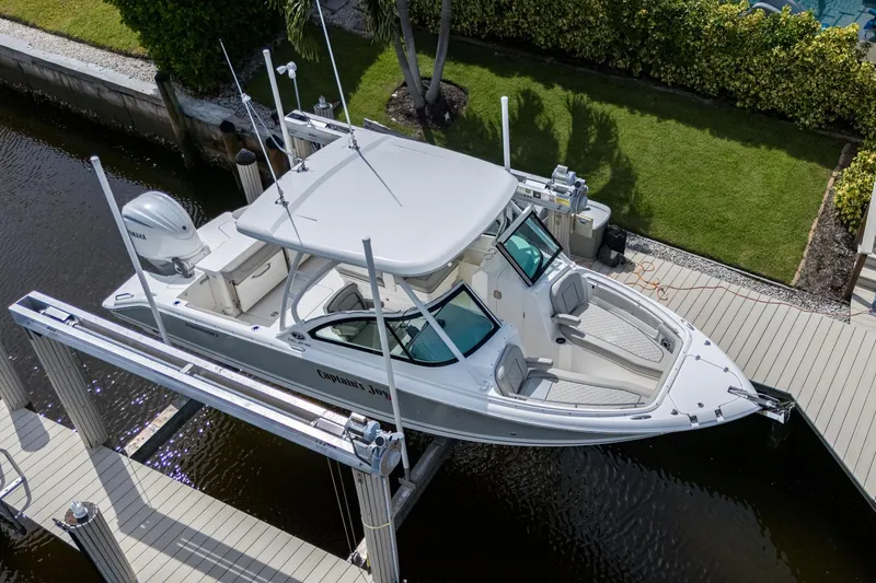 Slide: The Image of 2022 Pursuit DC 246 Dual Console boat docked on a lift, aerial view. - 42