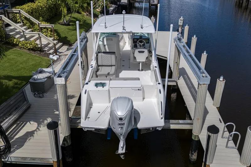 Slide: The Image of 2022 Pursuit DC 246 Dual Console boat docked at a marina, viewed from above. - 6