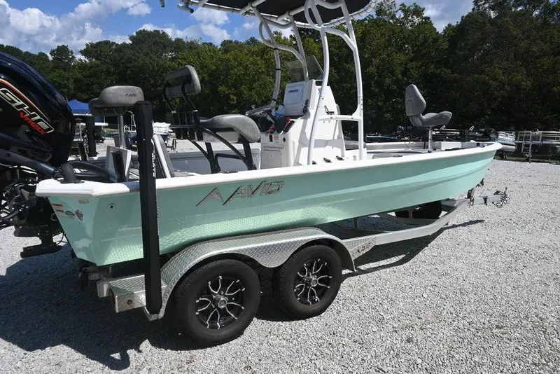 Slide: The Image of 2025 Avid 21 Mag boat on trailer, light blue hull, parked outdoors. - 3