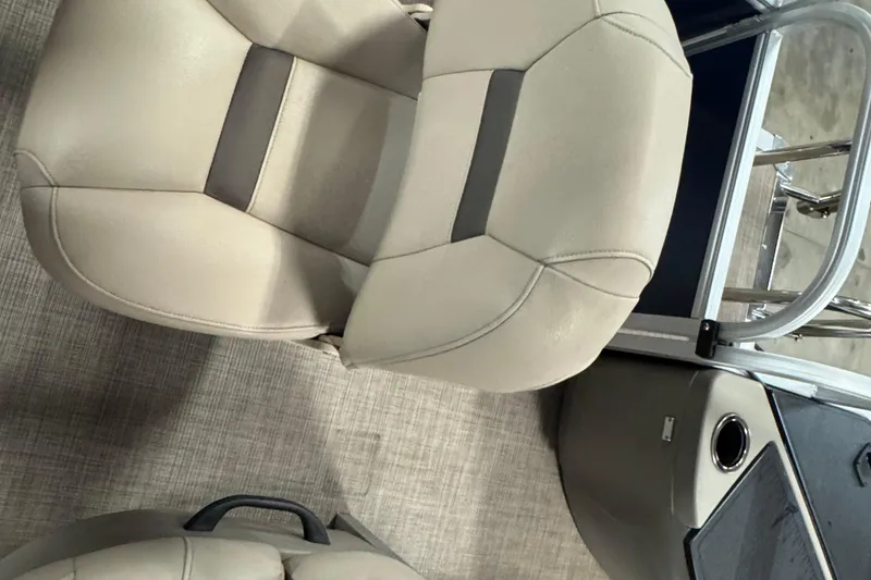 Slide: The Image of 2025 Sun Tracker Bass Buggy 18 DLX boat interior with beige seating and modern design. - 10