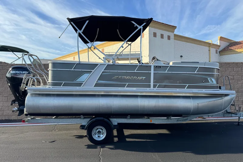 The Image of 2019 Starcraft EX 20 C pontoon boat with Mercury outboard motor on trailer. - 0