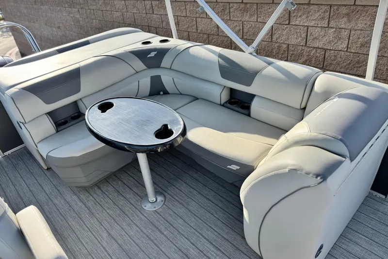 Slide: The Image of 2019 Starcraft EX 20 C pontoon boat interior with gray seating and round table. - 15