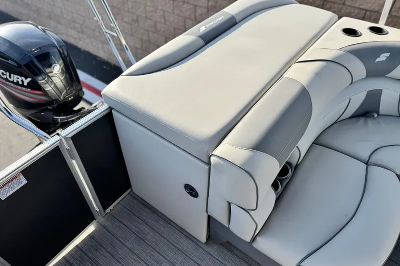 Slide: The Image of 2019 Starcraft EX 20 C boat interior with Mercury engine, featuring gray seating and cup holders. - 16