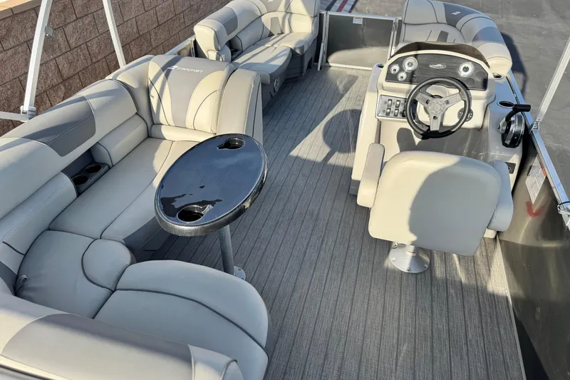 Slide: The Image of 2019 Starcraft EX 20 C pontoon boat interior with plush seating and steering console. - 19