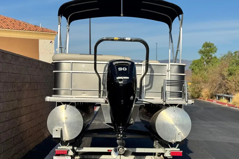 Slide: The Image of 2019 Starcraft EX 20 C pontoon boat with 90 HP motor on trailer. - 5