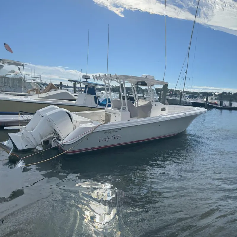 The Image of 2016 Edgewater 320CC boat named "Lady Grey" docked in a marina under a clear sky. - 0