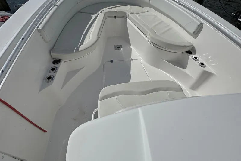 Slide: The Image of Interior view of a 2016 Edgewater 320CC boat, featuring white seating and cup holders. - 10
