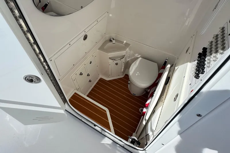 Slide: The Image of Interior of 2016 Edgewater 320CC boat bathroom with toilet and sink. - 12