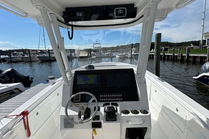 Slide: The Image of 2016 Edgewater 320CC boat dashboard with steering wheel and navigation system at marina. - 13