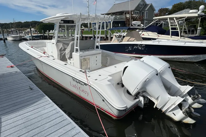 Slide: The Image of 2016 Edgewater 320CC boat named "Lady Grey" docked at a marina. - 2