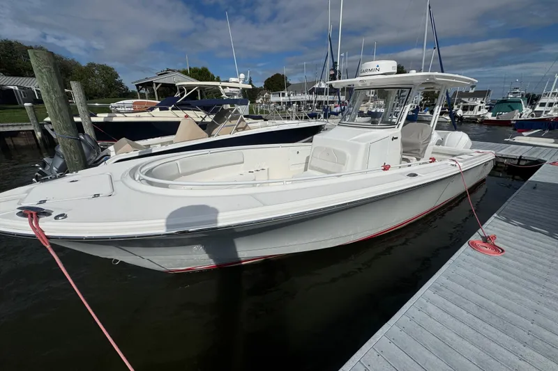 Slide: The Image of 2016 Edgewater 320CC boat docked at marina under blue sky. - 5