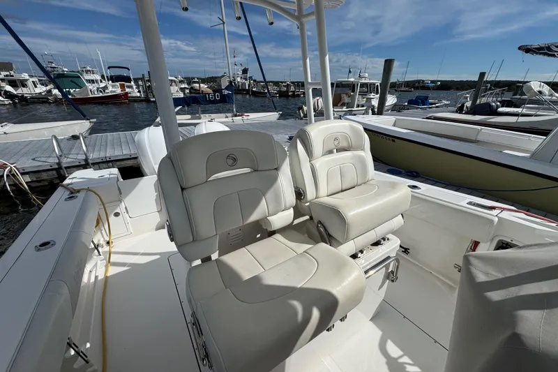 Slide: The Image of 2016 Edgewater 320CC boat interior with plush seating at a marina dock. - 6