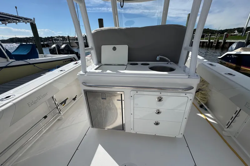 Slide: The Image of Edgewater 320CC 2016 boat interior with sink, storage, and docked marina view. - 8