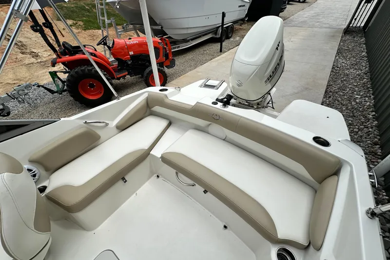 Slide: The Image of 2019 Stingray 191 DC boat interior with beige seating and Suzuki outboard motor. - 17